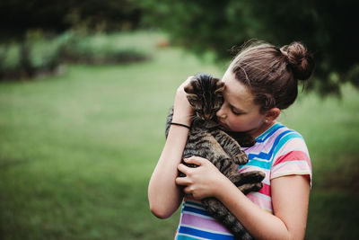 Rear view of woman holding girl outdoors