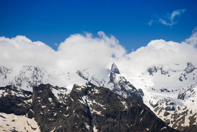 Scenic view of snowcapped mountains against blue sky