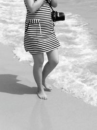 Low section of woman standing in water