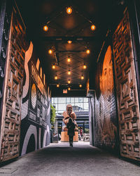 Rear view of woman standing in illuminated building