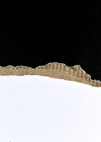 Close-up of snow covered land against black background