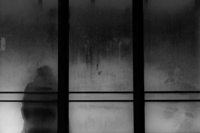 Silhouette person seen through glass