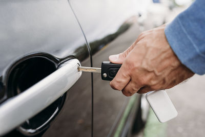 Hand of man locking car with key