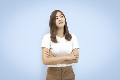 Portrait of young woman against white background