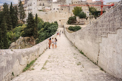 People walking on footpath amidst buildings in city