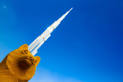 Low angle view of statue against clear blue sky