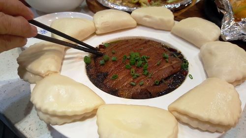 Close-up of hand holding food served in plate