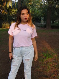Portrait of teenage girl standing on tree