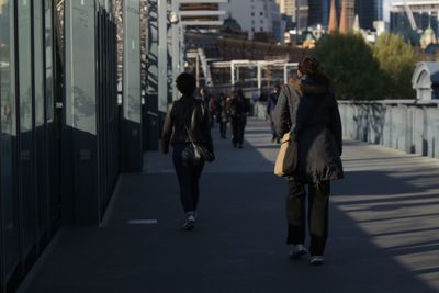 Rear view of women walking in city