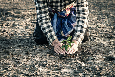 Midsection of man planting on field