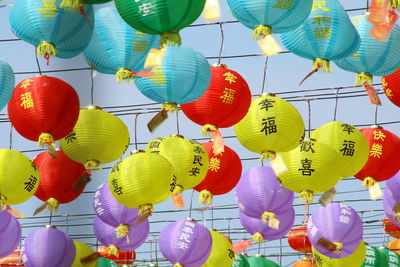 Low angle view of lanterns hanging against sky