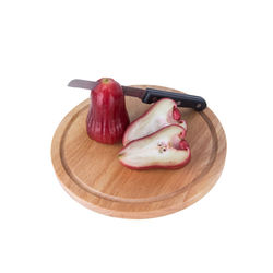 Close-up of sliced fruits on cutting board against white background