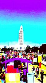 People walking in city against clear sky