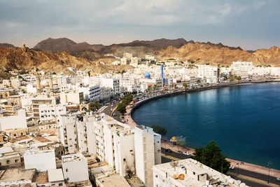 High angle view of townscape by sea against sky