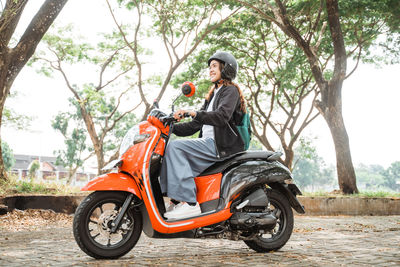 Man riding motor scooter on road