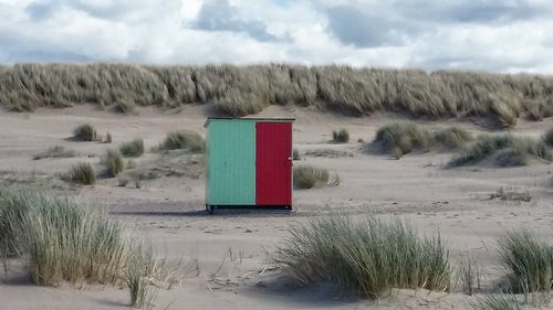 Lifeguard hut on field against sky during winter