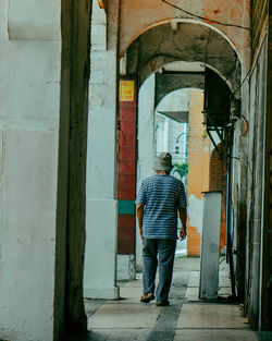 Rear view of man standing by building