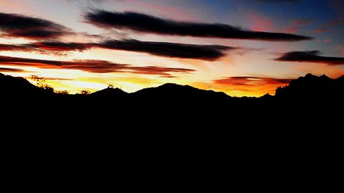 Silhouette of mountain against dramatic sky