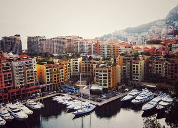 Boats moored at harbor against clear sky