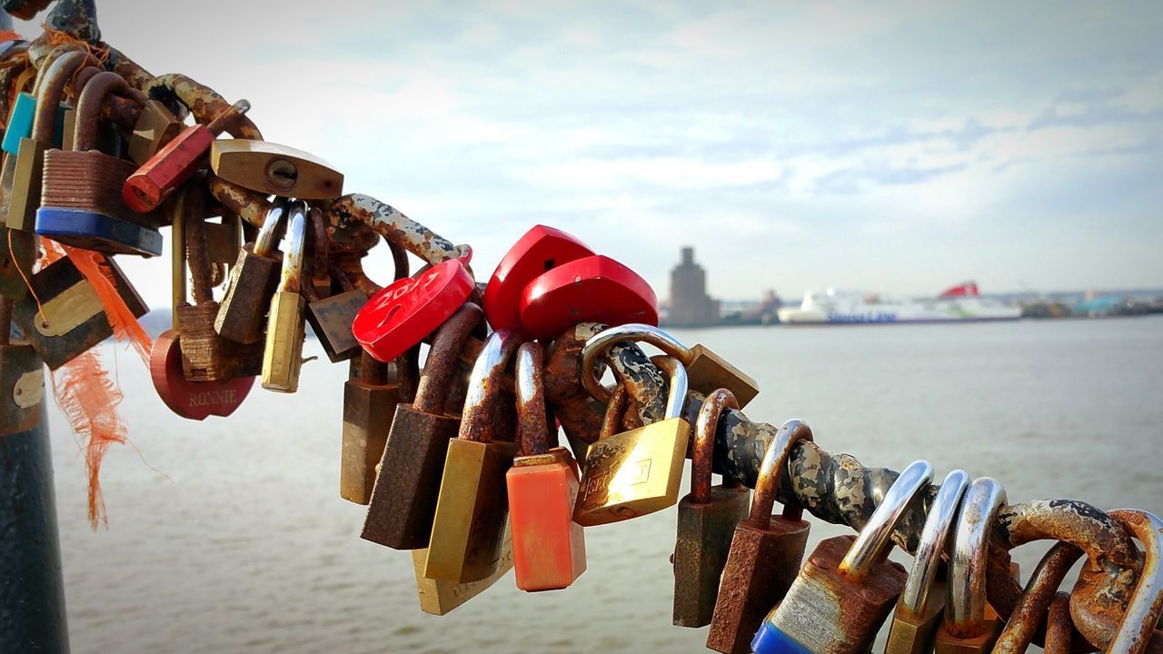 CLOSE-UP OF PADLOCKS ON RAILING BY RIVER