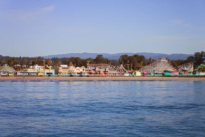 Scenic view of sea by buildings against sky