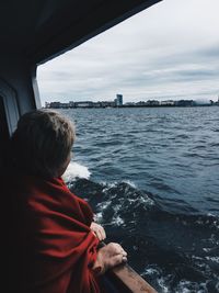 Woman looking at sea against sky