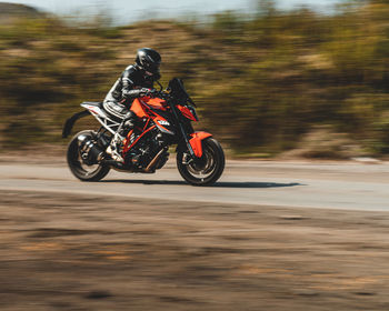 Blurred motion of person riding motorcycle on road