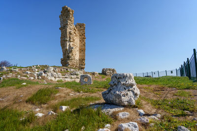 Rock formations on field against clear sky