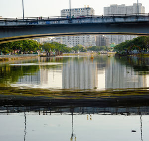 Bridge over river in city against sky
