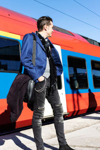 Low angle view of a businessman standing by a train at the station.