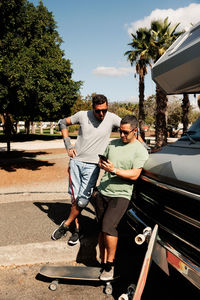 Two skateboarder friends chatting near their camper van in gran ganaria