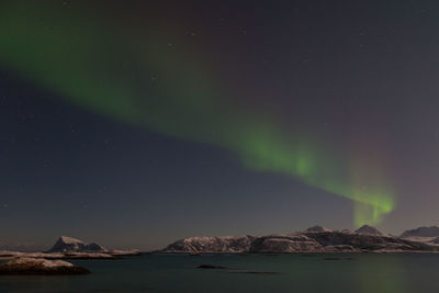 Scenic view of aurora borealis over sea at night