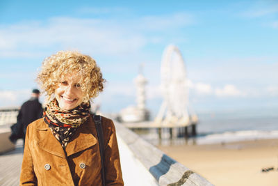 Portrait of smiling woman standing by the beach