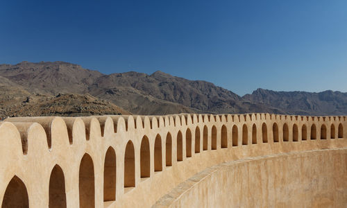 Arched wall against clear blue sky