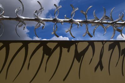 Low angle view of chainlink fence against sky