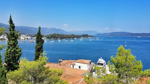 High angle view of buildings by sea against blue sky