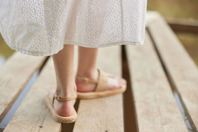 Low section of woman standing on boardwalk