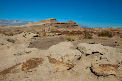 Rock formations in desert against blue sky