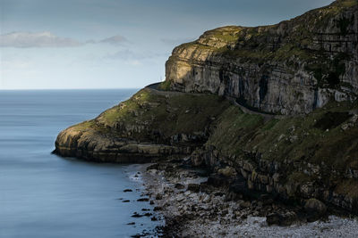 Rock formations by sea against sky