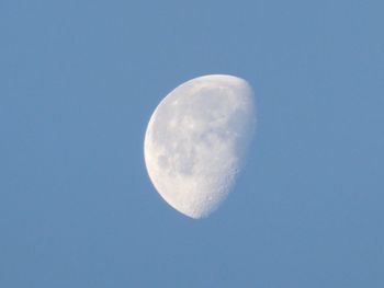 Low angle view of moon against clear blue sky