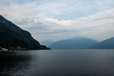 Scenic view of sea by mountains against sky