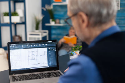 Midsection of man using laptop at office