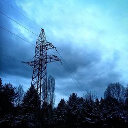 Low angle view of electricity pylon against cloudy sky