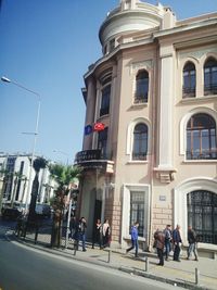 People walking on street against buildings in city