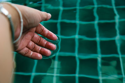 Close-up of person hand in swimming pool