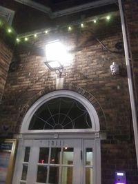 Low angle view of illuminated light hanging on building