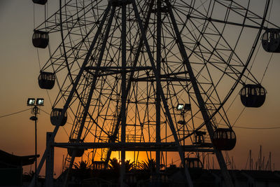 Low angle view of silhouette ferris wheel against sky