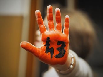 Close-up of hand holding orange pumpkin