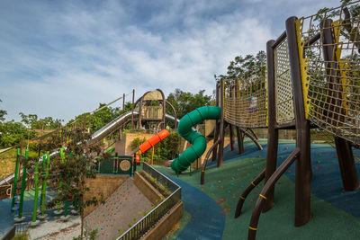 View of playground by swimming pool against sky