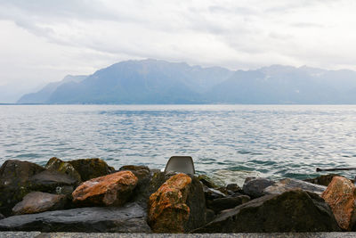 Scenic view of sea and mountains against sky